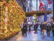  ?? Brittainy Newman Associated Press ?? AMERICANS are largely heeding calls not to panic over Omicron. Above, New Yorkers outside Macy’s.