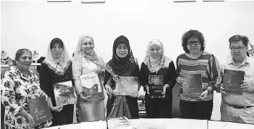  ??  ?? Fatimah (centre), director of Sarawak Women and Family Department Noriah Ahmad (third left) and others hold the previously published books on Sarawak women.