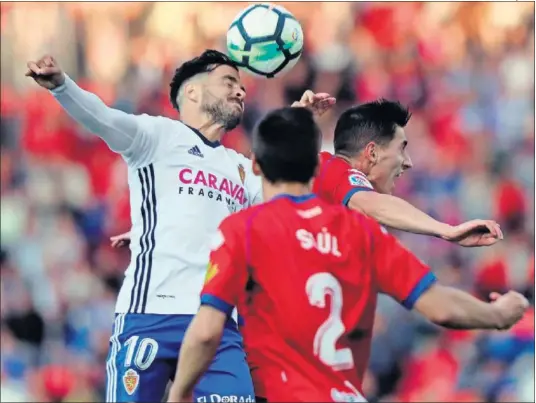  ??  ?? MÁXIMA INTENSIDAD. El zaragocist­a Ros pelea por un balón con un jugador del Numancia, ante la mirada de Saúl.