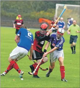 ?? Photo: Kevin McGlynn ?? No way through for Lochside’s Lewis Buchanan as he’s crowded out by the Kyles defence during an enthrallin­g South Division One game held at a soggy Mossfield Stadium last Saturday.