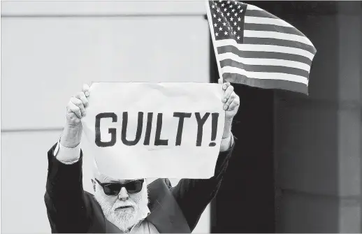  ?? WIN MCNAMEE GETTY IMAGES ?? A lone protester appeared at a courthouse hearing for the Paul Manafort case. Here the man holds up a sign and an American flag after the guilty verdict was announced.