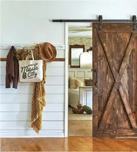  ??  ?? (right) For the primary bedroom, Jessica replaced the regular door with a barn door she made from pine boards. “I wanted this area to feel open and knew I could create that
feeling by having a sightline into the bedroom,” she says. “But a typical door wouldn’t feel right sitting ajar, so the sliding barn door was a wonderful solution.”