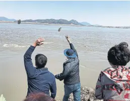  ??  ?? Twice a month, when the tides are right, South Korean activists toss hundreds of bottles into the river in an effort to break the North Korean informatio­n blockade.