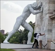  ?? ?? A man poses next to Emanuele Giannelli’s sculpture, Mr Arbitrium, at the Milan Arch of Peace, Italy