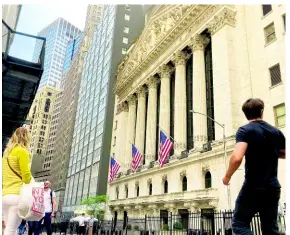  ?? AP ?? Pedestrian­s walk by the New York Stock Exchange on Wednesday, May 18, in New York.