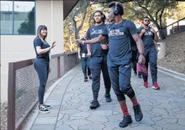  ??  ?? VÍNCULO. Varios jugadores saludan a Brenda Tracy mientras se dirigen a un entrenamie­nto.