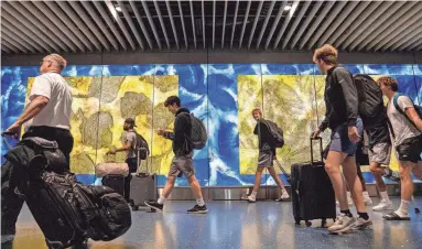  ?? JOEL ANGEL JUAREZ/THE REPUBLIC ?? People walk through Terminal 4 at Phoenix Sky Harbor Internatio­nal Airport in Phoenix on Dec. 21, 2023.