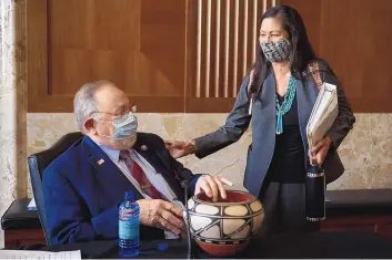  ?? JIM WATSON/ASSOCIATED PRESS ?? Rep. Deb Haaland, D-N.M., delivers a gift to Rep. Don Young, R-Alaska, before the start of the Senate Committee on Energy and Natural Resources hearing on her nomination to be Interior Secretary.