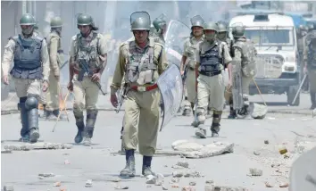  ?? — AFP ?? Paramilita­ry troopers patrol after a clash with protesters in Srinagar.