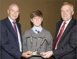  ??  ?? Matthew Colgan being presented with the Kathleen Fahy Award by retired Chief Superinten­dent John Roche and principal Michael McMahon.