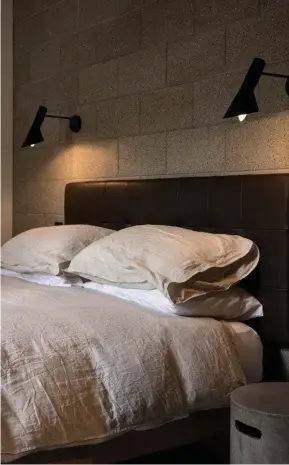  ??  ?? Above Black ‘AJ’ wall lights by Arne Jacobsen for Louis Poulson contrast against the concrete block wall in the main bedroom.