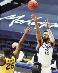  ?? David Butler II / Associated Press ?? UConn’s Tyler Polley (12) shoots a 3-pointer against Marquette in Storrs.