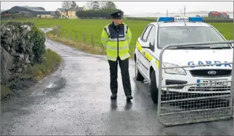  ?? FRANK MCGRATH ?? A garda at the scene near the Biggins farm in Glencorrib, Co Mayo.