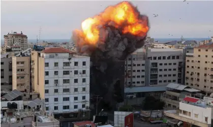  ?? ?? Fire and smoke rise after an Israeli air strike on the National Bank in Gaza City, 8 October 2023. Photograph: Ahmed Zakout/AFP/Getty Images