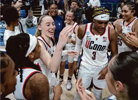  ?? Joe Buglewicz/Getty Images ?? UConn’s Paige Bueckers (5), Aaliyah Edwards (3) and teammates celebrate Monday’s NCAA Tournament win over Syracuse.