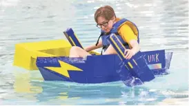  ?? PHOTOS BY PATRICK BREEN/THE REPUBLIC ?? Annie Graziano of Desert Vista High School paddles the SS Unk Thursday at the Kiwanis Park rec center in Tempe. Engineerin­g students built boats with cardboard and duct tape.