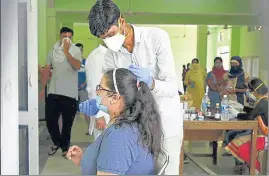  ?? PARVEEN KUMAR/HT ?? A health worker collects a swab sample of a woman in Gurugram on Friday