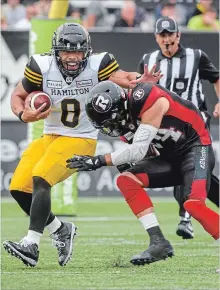  ?? GARY YOKOYAMA THE HAMILTON SPECTATOR ?? Jeremiah Masoli can’t escape the grasp of Ottawa’s Anthony Cioffi during the Redblacks win in Hamilton on July 28.