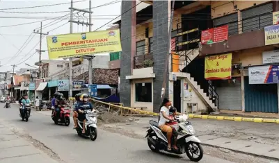  ?? ALFIAN RIZAL/JAWA POS ?? ADA DUA PEDAGANG YANG POSITIF KORONA: Spanduk bertulisan Pasar Kupang Gunung dan Pasar Jarak ditutup hingga 16 Mei.