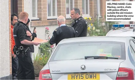  ??  ?? HELPING HAND: Colin Mackay, centre, chats with police officers outside the old mission building where the crew were accommodat­ed