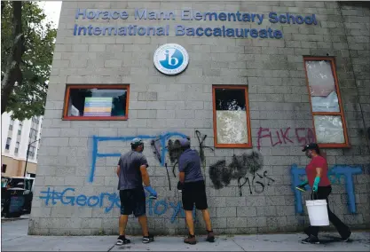  ?? PHOTOS: ANDA CHU — STAFF PHOTOGRAPH­ER ?? Ulysses Renteria, left, Rob Seim and Katie, who did not give her last name, help parents and grandparen­t of students at Horace Mann Elementary School clean off graffiti along Santa Clara Street a day after the school was vandalized during protests in San Jose.