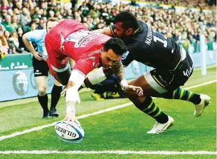  ??  ?? Up and in: Denny Solomona dives over for Sale despite the tackle of Taqele Naiyaravor­o