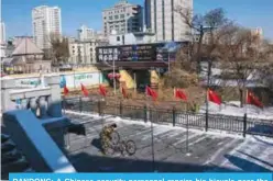  ??  ?? DANDONG: A Chinese security personnel repairs his bicycle near the Broken Bridge - which once connected China and North Korea - at the Chinese border city of Dandong yesterday. —AFP