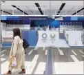  ?? Hiro Komae / Associated Press ?? A woman walks past a shop selling souvenirs of the Tokyo 2020 Olympic games at the Narita Internatio­nal Airport in Narita, north of Tokyo, on Thursday.