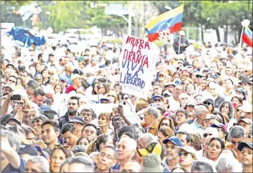  ??  ?? Anti-government activists listen to Guaido during an extraordin­ary open meeting in front of the headquarte­rs of the United Nations Developmen­t Programme (UNDP) in Caracas. — AFP photo