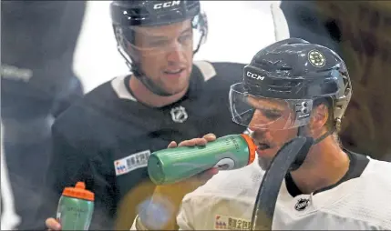  ?? MATT STONE PHOTOS / BOSTON HERALD ?? David Krejci, right, drinks from a water bottle during practice on Tuesday at Warrior Ice Arena.
