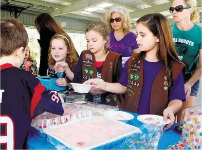  ?? Jerry Baker / For the Chronicle ?? Brooklyn Cardenas, 8, from right, a third grader and Brownie Girl Scout Troop GSSJC 117032 member, teams up with fellow Girl Scout Brownies Clara Grace Evans, 9, and Charlize Phin, 8, to serve customers during a bake sale fundraiser at Willow Creek...