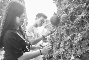  ??  ?? Stytany Kho and Melvin Janggaank Rupitan put some finishing touches on a Christmas tree in front of St Thomas Cathedral in Kuching. The Holy Communion service with hymns commences at 6.30am today at the church, followed by the solemn liturgy with...