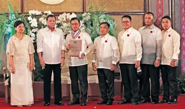  ??  ?? PRESIDENT Rodrigo Duterte congratula­tes the City Agricultur­e Office of LGU Tagum for winning the 2019 CSC Pagasa Award for its Tagumpay Agrivolvin­g Fund. Malacañang Presidenti­al Photo