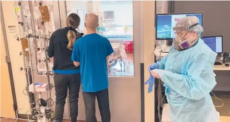  ?? ANDREW SELSKY/AP ?? Visitors peer into the room of a COVID-19 patient last week at Salem Hospital in Oregon as a nurse dons protective gear before going into the room of another patient. The highly contagious delta variant is hammering the state.