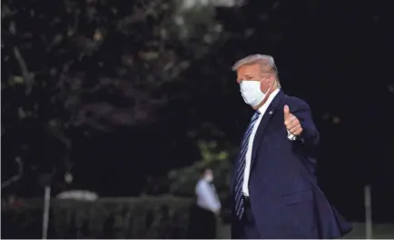  ?? NICHOLAS KAMM/AFP VIA GETTY IMAGES ?? President Donald Trump arrives at the White House late Monday from Walter Reed Medical Center in Bethesda, Maryland, where he was treated for COVID-19. His treatment will continue at the White House.
