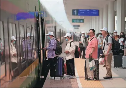  ?? XING GUANGLI / XINHUA ?? Passengers prepare to board the first cross-border passenger train from Kunming in Southwest China’s Yunnan province to Vientiane, the capital of Laos, on April 13.