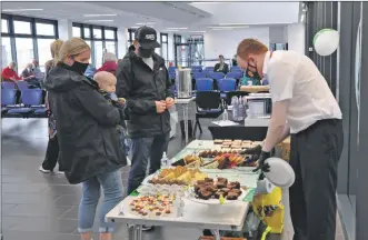  ?? 01_B40CalMac0­4 ?? Right: Euan Stout serves up delicious treats while a youngster looks on in anticipati­on.