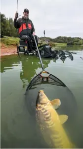  ?? ?? An 8lb mirror – John’s biggest fish of the day – slides over the waiting landing net