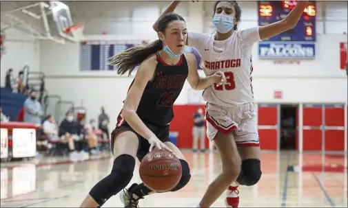  ?? SHAE HAMMOND — STAFF PHOTOGRAPH­ER ?? Los Gatos’ Belle Bramer dribbles the ball against Saratoga’s Naomi Mallik during the second quarter at Saratoga High School in Saratoga on Jan. 14. Los Gatos won, 58-40, as Bramer led the Wildcats with 13 rebounds.