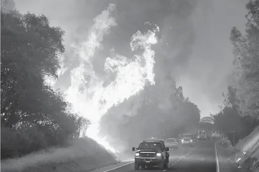  ?? — Gambar AFP ?? DAHSYAT: Pengguna jalan raya meredah haba panas ketika kebakaran ‘Wall Fire’ marak di sepanjang Jalan Forbestown di Oroville, California kelmarin.