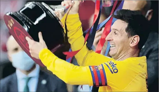  ?? EP ?? Un feliz Leo Messi levanta el trofeo que acaba de recoger en el palco y lo enseña a sus compañeros que le esperan en el césped