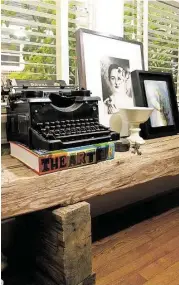  ??  ?? In the dining room, one of Murphy’s antique typewriter­s rests on a low bench made from a heavy wooden beam salvaged from an old church.