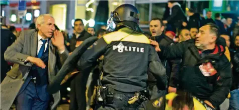  ?? AP ?? Demonstran­ten warfen gestern Morgen vor dem türkischen Konsulat in Rotterdam Flaschen und Steine – die Polizei griff ein.