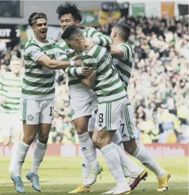  ?? ?? 0 Tom Rogic is mobbed by his team-mates after scoring Celtic’s equaliser in the seventh minute