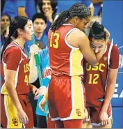  ?? ?? USC'S RAYAH MARSHALL, center, comforts Watkins, right, who fell and hit the court hard.