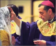  ?? Ned Gerard / Hearst Connecticu­t Media file photo ?? Bishop Frank Caggiano administer­s ashes to the forehead of Angela Cipri, of Bridgeport, during an Ash Wednesday Mass at St. Augustine’s Cathedral, in Bridgeport on March 6, 2019. Because of the COVID-19 pandemic, this year priests will either sprinkle ashes on people’s heads or use a cotton swab to apply them.