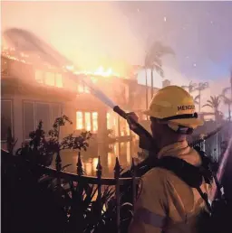  ?? MARCIO J. SANCHEZ/AP ?? A firefighte­r works to put out a structure burning during a wildfire in Laguna Niguel, Calif., on May 11.