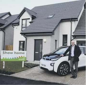  ??  ?? Springfiel­d chief executive Innes Smith with an electric car from Douglas Park BMW Hamilton