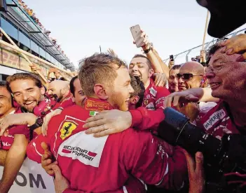  ?? FOTO: IMAGO ?? Sebastian Vettel feiert mit den Ferrari-Mitarbeite­rn seinen Sieg beim Auftakt der Formel-1-Saison in Melbourne. Der 29-Jährige gewann vor Mercedes-Pilot Lewis Hamilton, der 9,9 Sekunden Rückstand hatte.