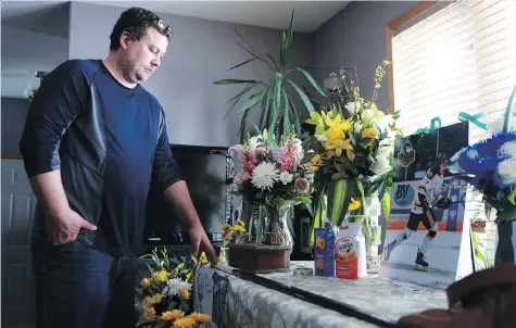  ?? MICHELLE BERG ?? Scott Thomas stands in his Saskatoon home next to a table filled with flowers, food and other items that honour his son Evan Thomas, one of the Humboldt Broncos killed in last Friday’s bus crash. A funeral for the 18-year-old will be held April 16 at...